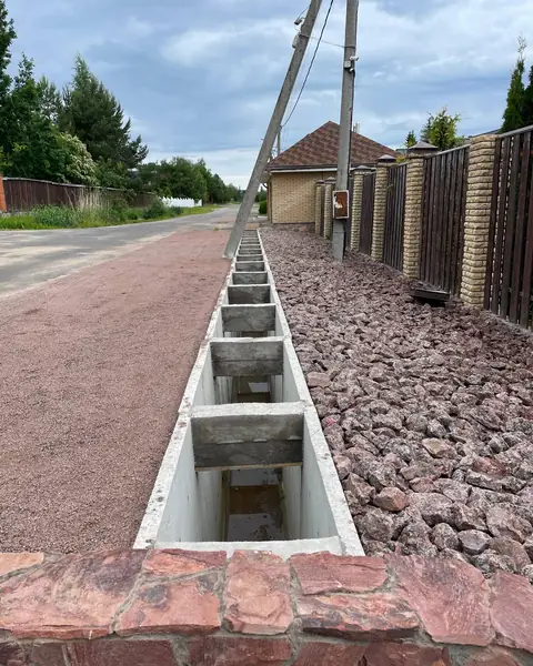 Открытые лотки вдоль кирпичного забора